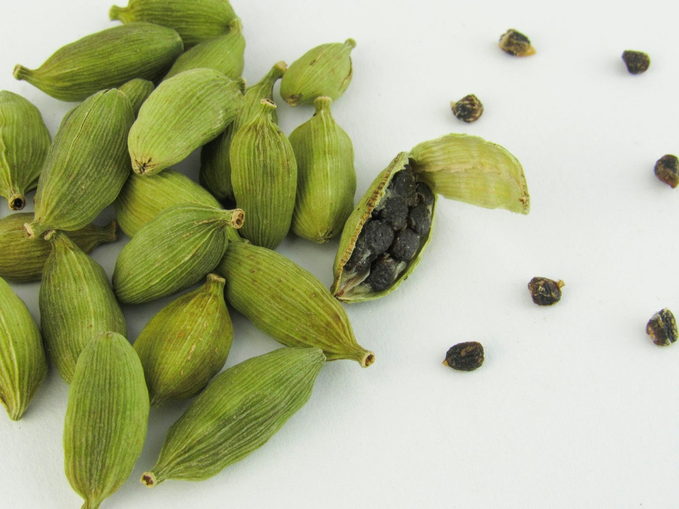 Green cardamom pods, one split open to show the seeds