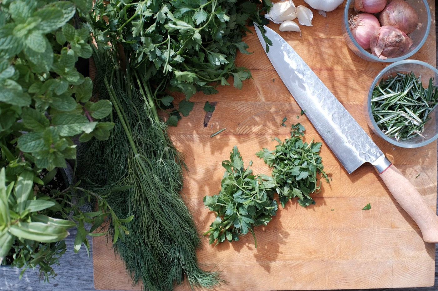 Fresh herbs on a chopping board with a knife