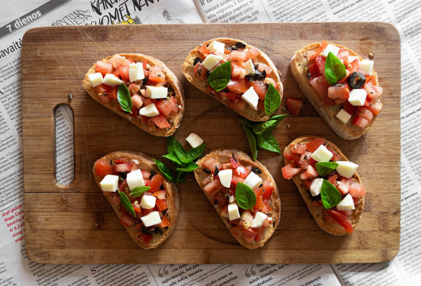 Bruschetta with tomato and basil on a wooden board