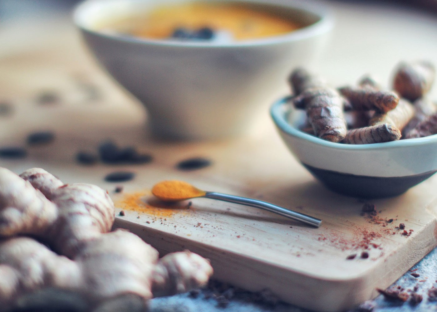 Turmeric powder and fresh turmeric root on a wooden board