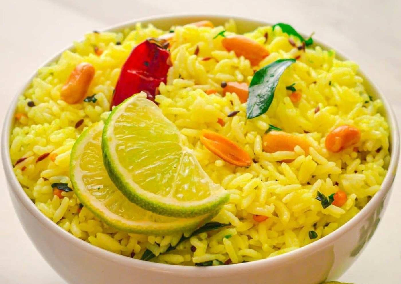 Bowl of yellow turmeric rice with lime and vegetables
